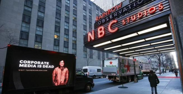 Tucker Carlson instalează panouri publicitare “Mass-media corporatistă a murit” în fața sediilor NYTimes, CNN, MSNBC și Washington Post